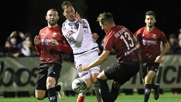 Melbourne Victory's James Troisi battles for possession with a couple of Hume City defenders.