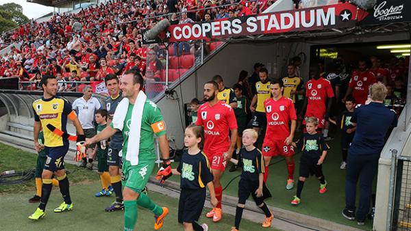 Central Coast and Adelaide United players walk onto Coopers Stadium.