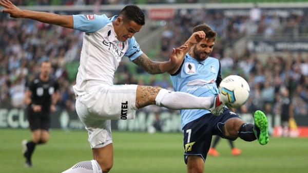 City attacker Tim Cahill challenges for the ball with Sydney FC defender Michael Zullo.