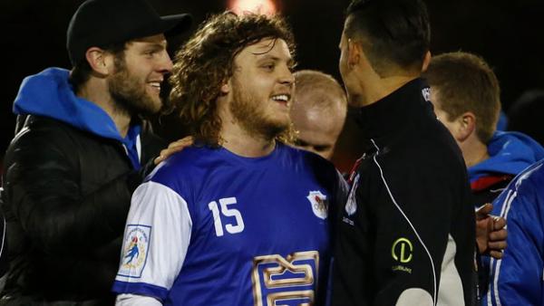 Canberra Olympic players celebrate a win in the FFA Cup.