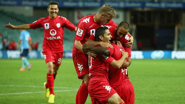 Adelaide United players celebrate their third goal.